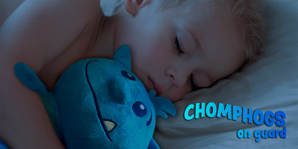 toddler boy sleeping with blue plush toy called chomphog that helps him with his fear of the dark, with text overlay Chomphogs on guard